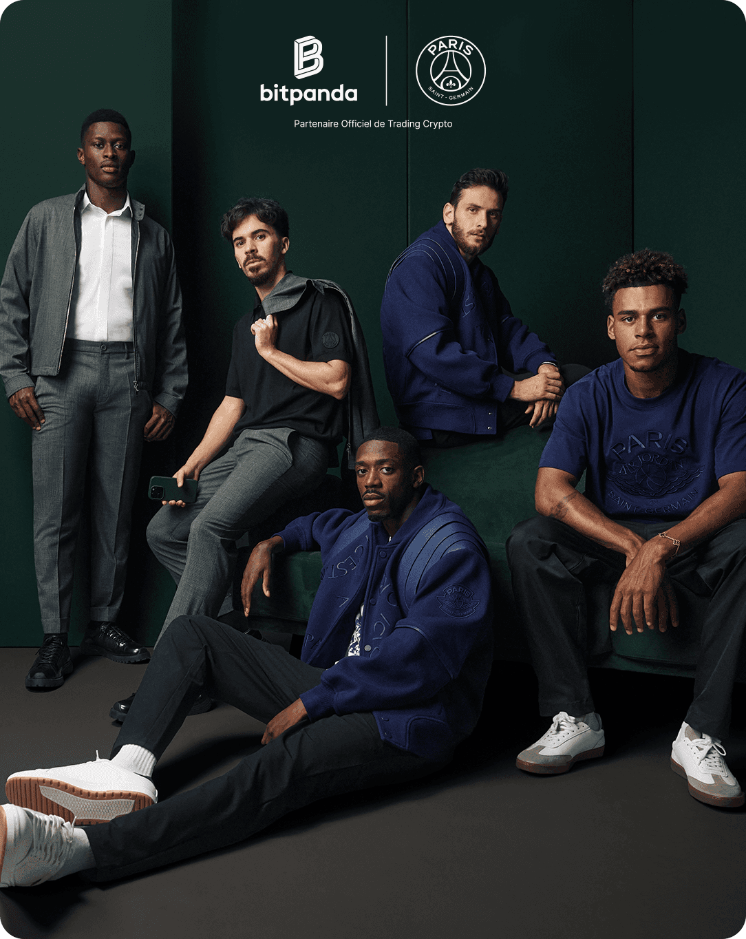 Five men in stylish, coordinated outfits pose confidently indoors against a dark green backdrop, with Bitpanda and Paris Saint-Germain logos above.