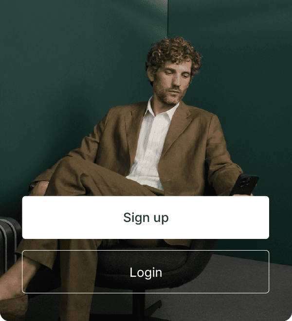 Man in a brown suit sits in a modern chair checking his phone, with large “Sign up” and “Login” buttons overlaid at the bottom.