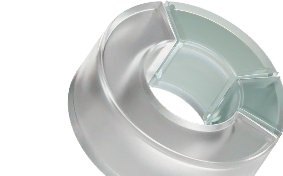 A transparent, cylindrical plastic object with a cross-shaped divider inside, viewed from an angle.